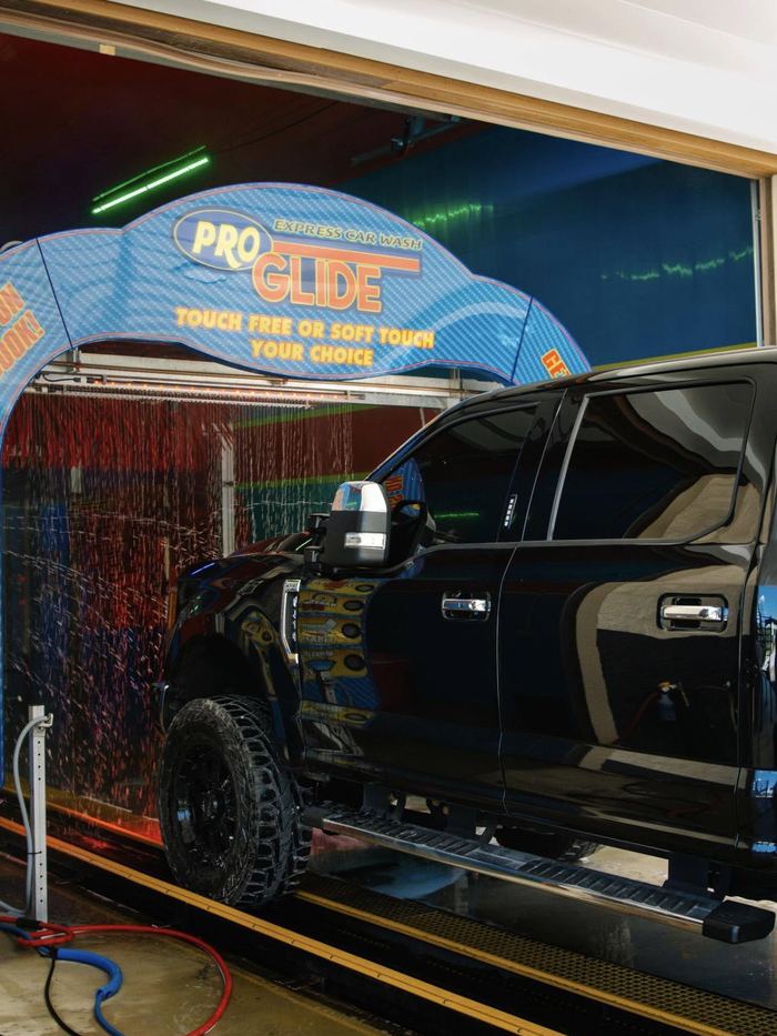 Black pickup truck in the ProGlide wash tunnel under the Touch Free or Soft Touch arch